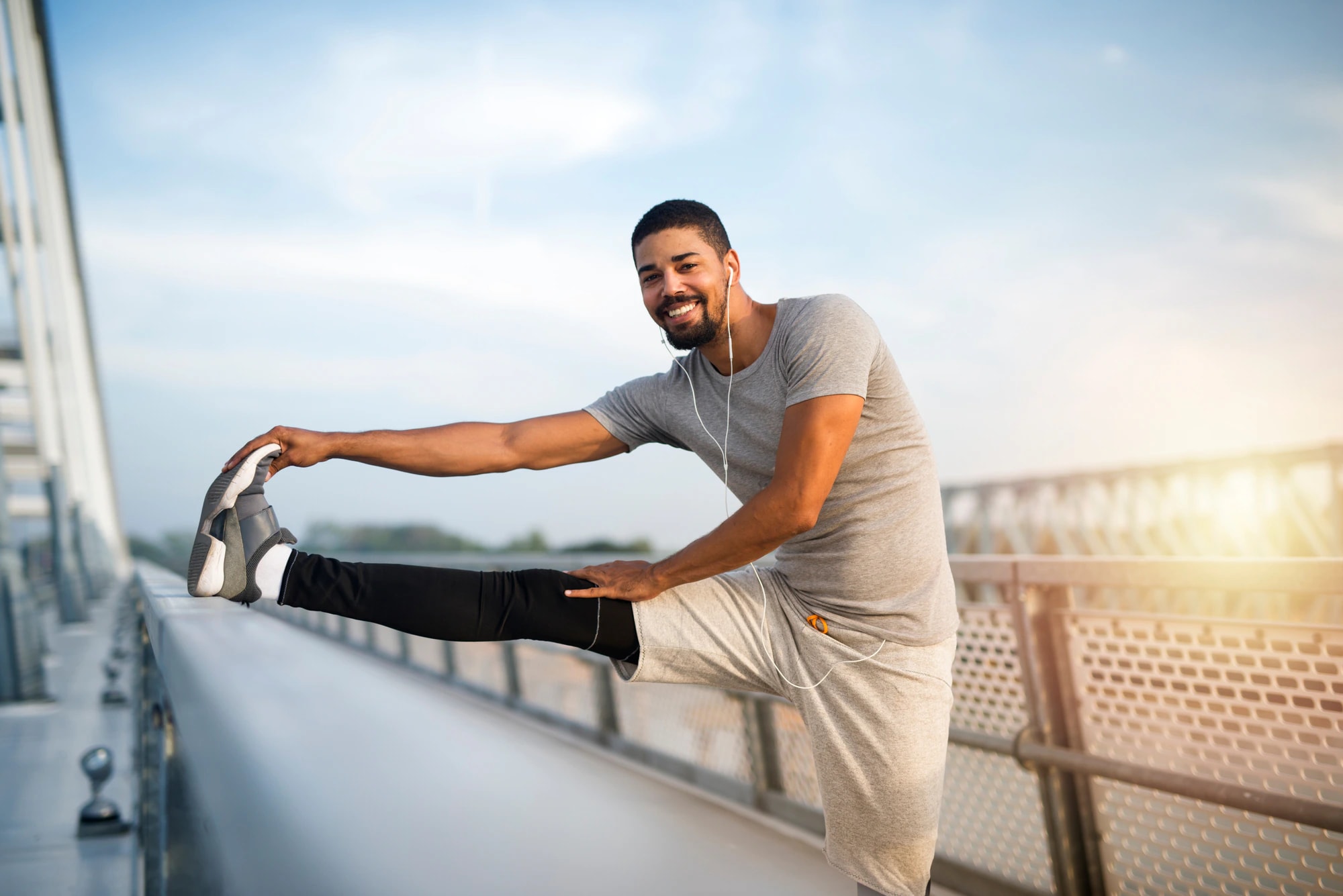 A man stretching outdoors by the water