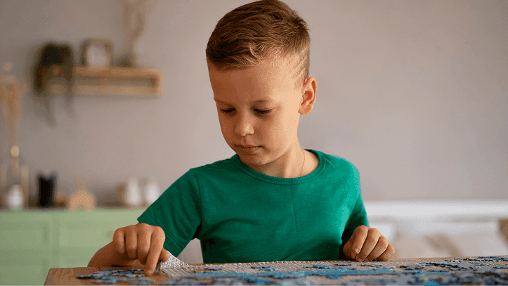 Young boy focused on assembling a puzzle