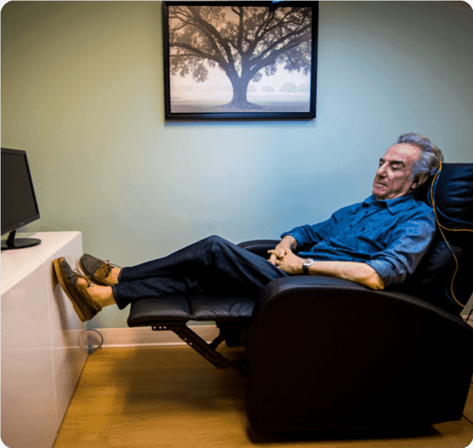 Man relaxing in a recliner during a neurofeedback session