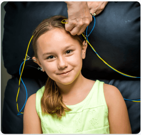 Young girl smiling during a NeurOptimal neurofeedback session